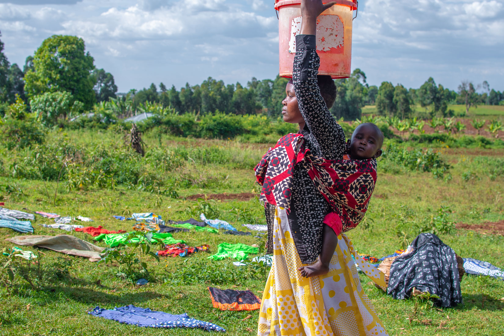 Woman and children pouring and transporting water